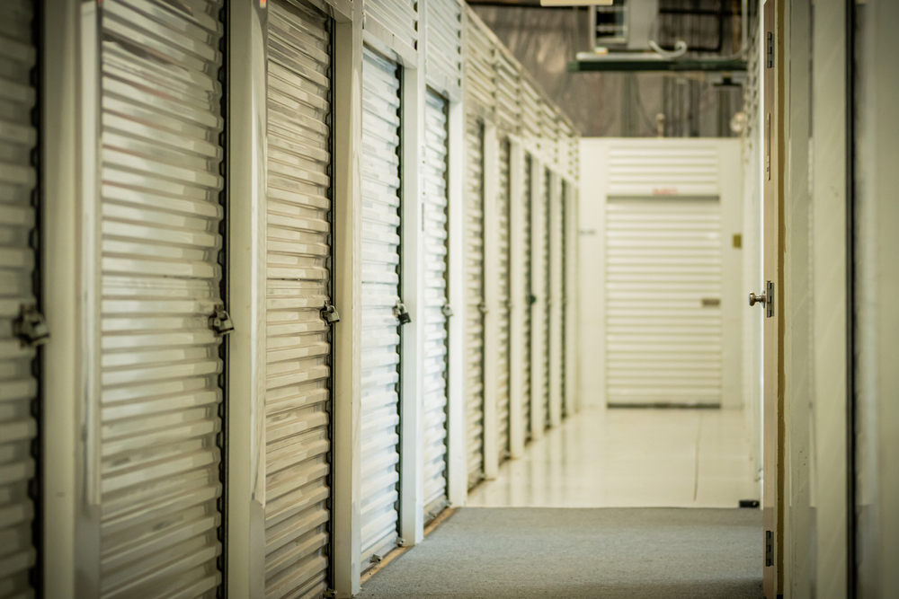 A,row,of,white,storage,unit,doors,with,padlocks,in